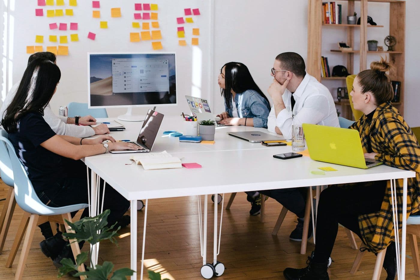 A team working together around a table in a bright meeting room.